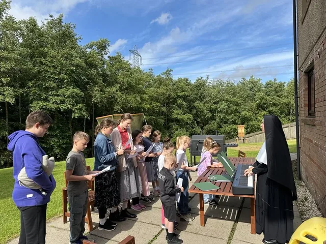 A Sister directing students outdoors.