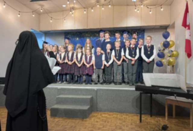 Students singing under the direction of a Sister.